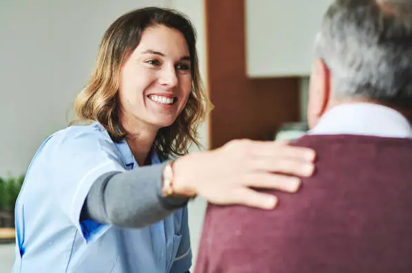 Healthcare professional supporting a person with dignity and care